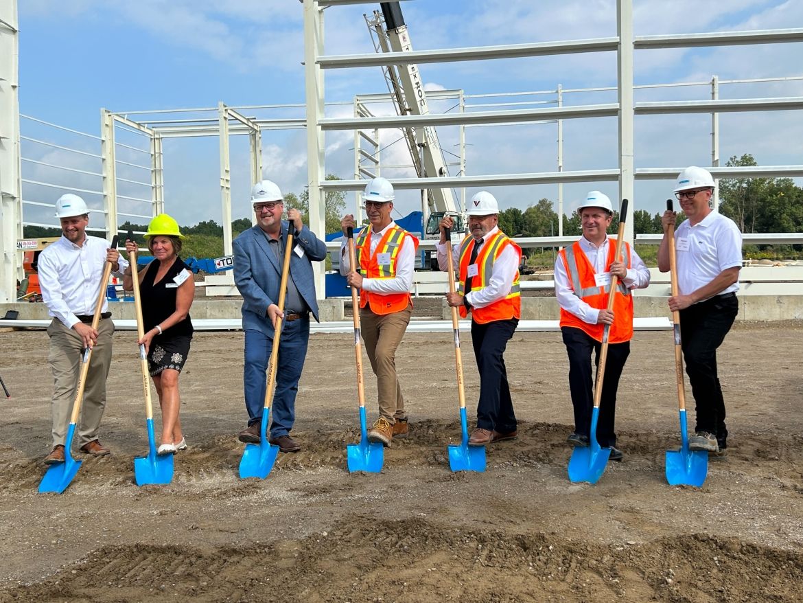 staff standing with shovels on industrial site