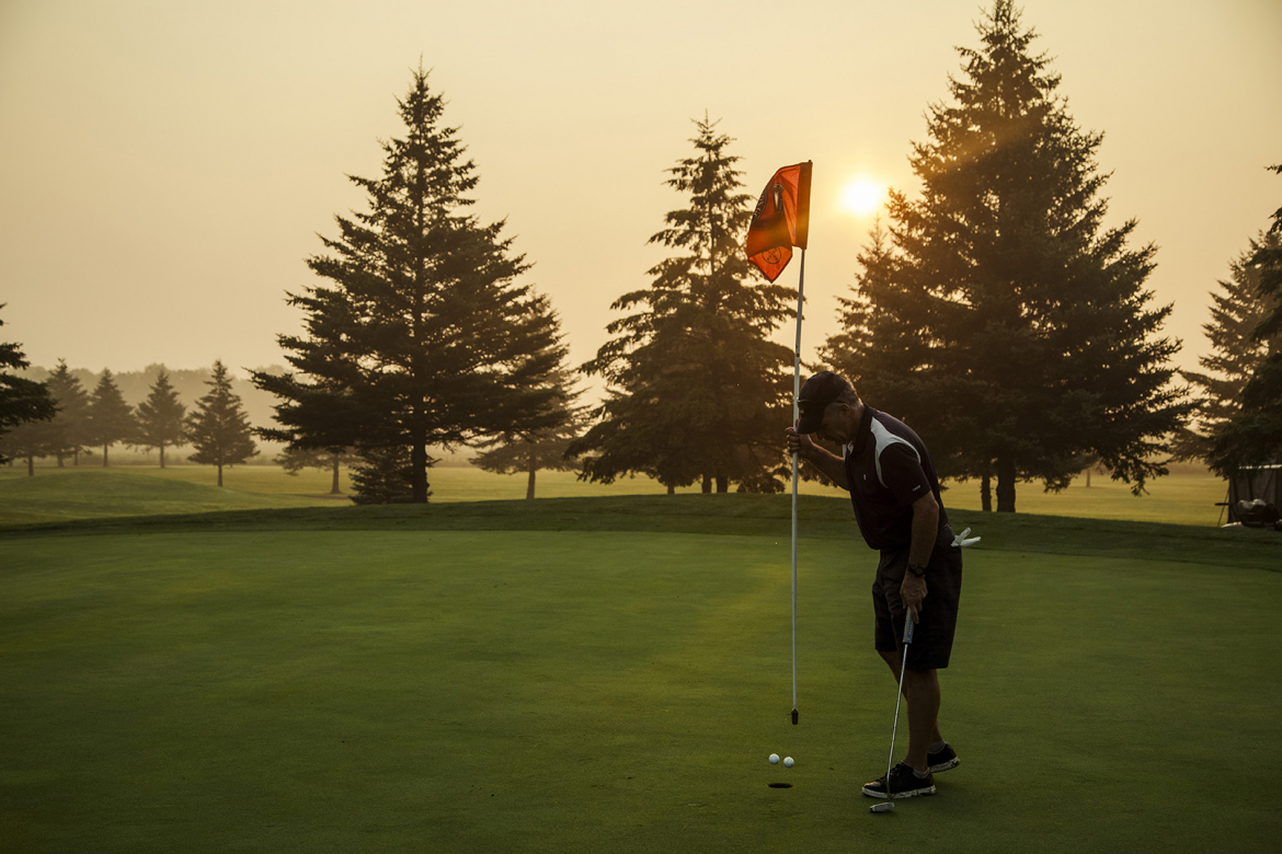 Man golfing with the sunset 